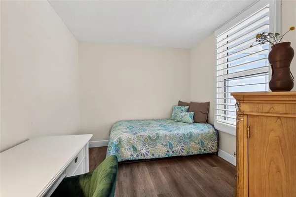 a bathroom with a granite countertop sink a mirror a toilet and shower