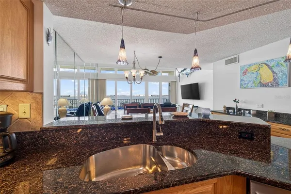 a view of a dining room and livingroom with furniture wooden floor a chandelier