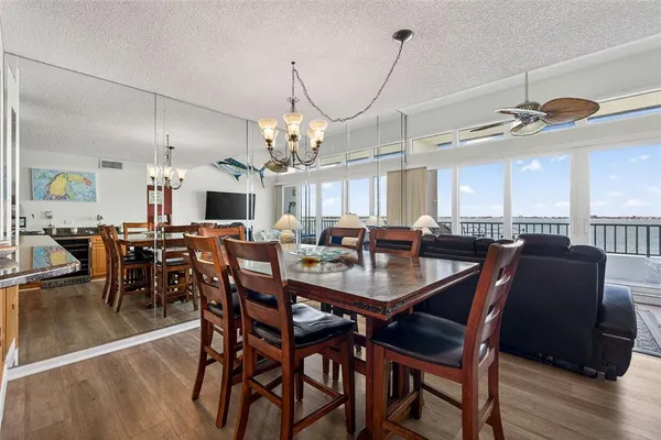 a view of a dining room with furniture a chandelier and wooden floor