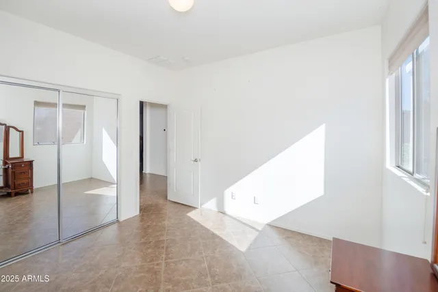 an empty room with a cabinet and mirrors