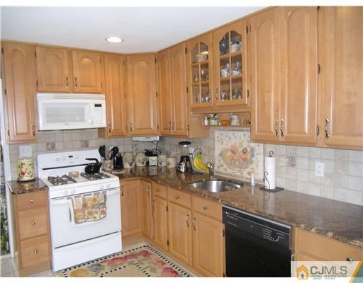 242 New Road Monmouth Junction, NJ 08852 - Photo 5 of 11 a kitchen with stainless steel appliances granite countertop a stove a sink and a microwave