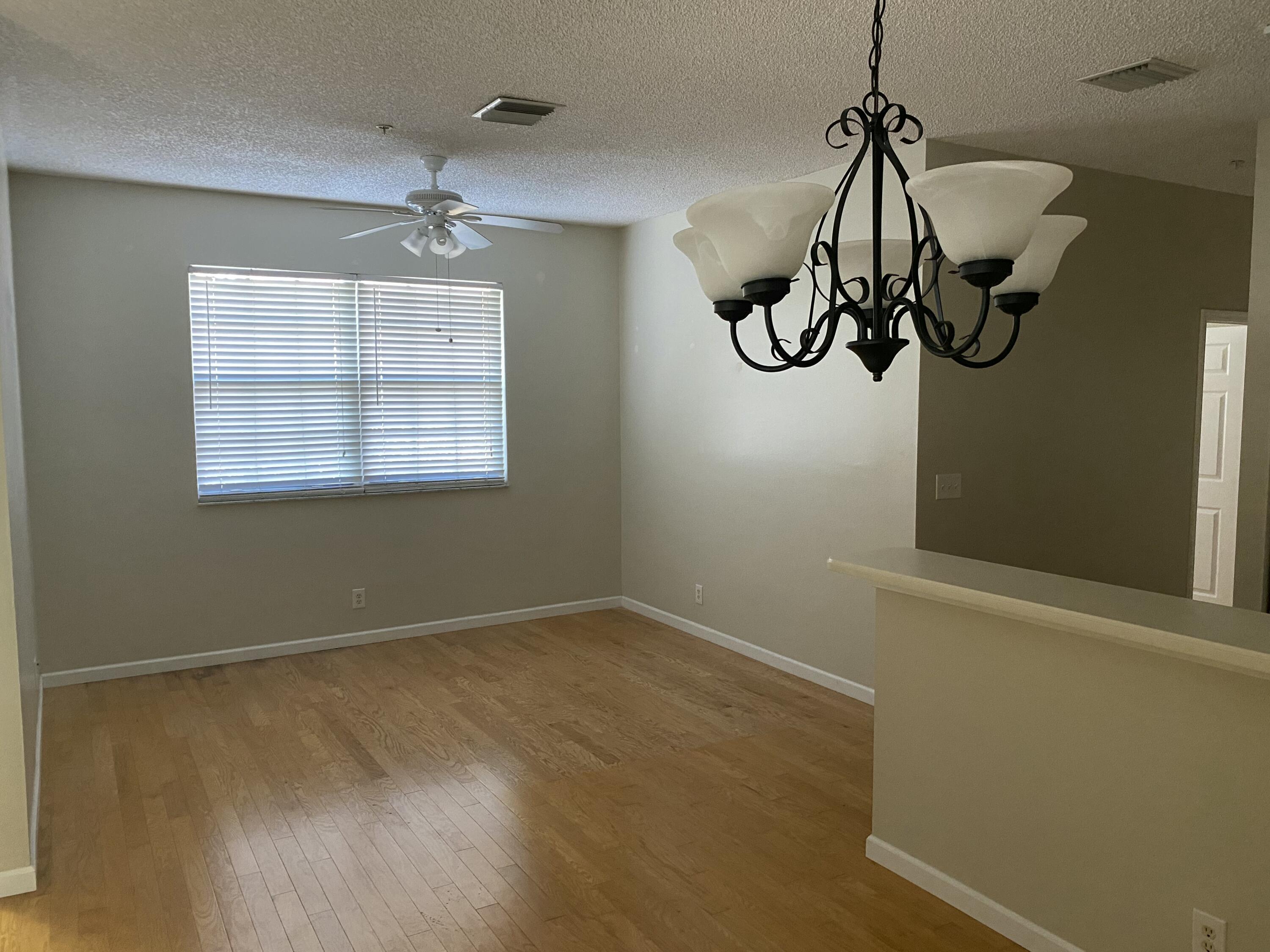 101 Lighthouse Circle, Unit J Tequesta, FL 33469 - Photo 7 of 13 a view of a room with a chandelier fan and wooden floor