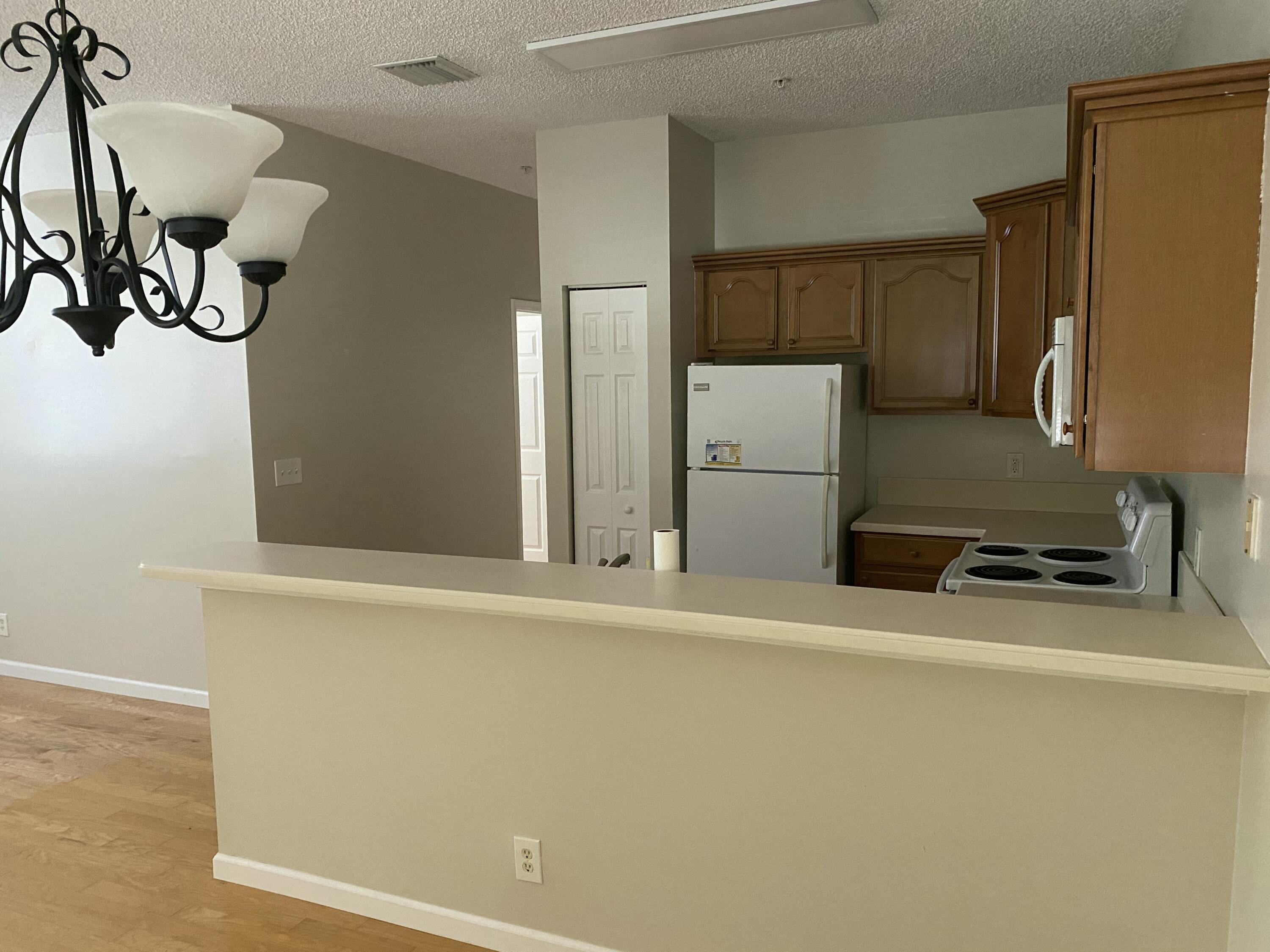 101 Lighthouse Circle, Unit J Tequesta, FL 33469 - Photo 9 of 13 a room with a refrigerator and a window