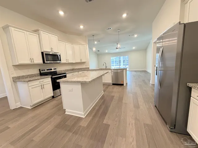 a kitchen with a sink a counter top space stainless steel appliances and cabinets