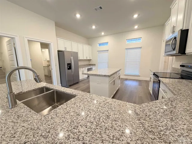 a kitchen with stainless steel appliances kitchen island a refrigerator sink and stove