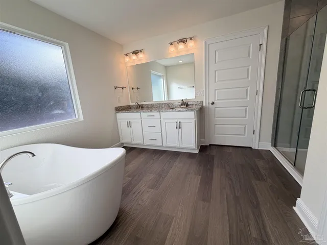 a bathroom with a bathtub sink and mirror