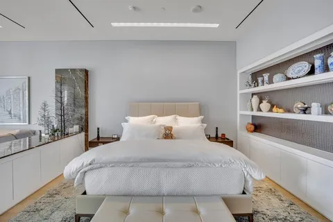 a bedroom with a bed and a large mirror