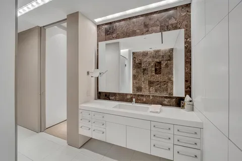 a bathroom with a double vanity sink mirror and shower