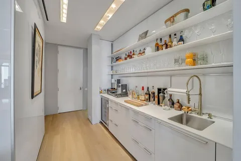 a kitchen with a sink a refrigerator and cabinets