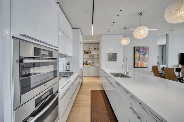 a large kitchen with kitchen island granite countertop a large counter top and stainless steel appliances