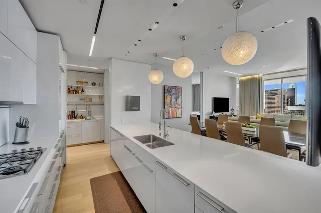 a large kitchen with stainless steel appliances a stove a sink dishwasher and a flat screen tv