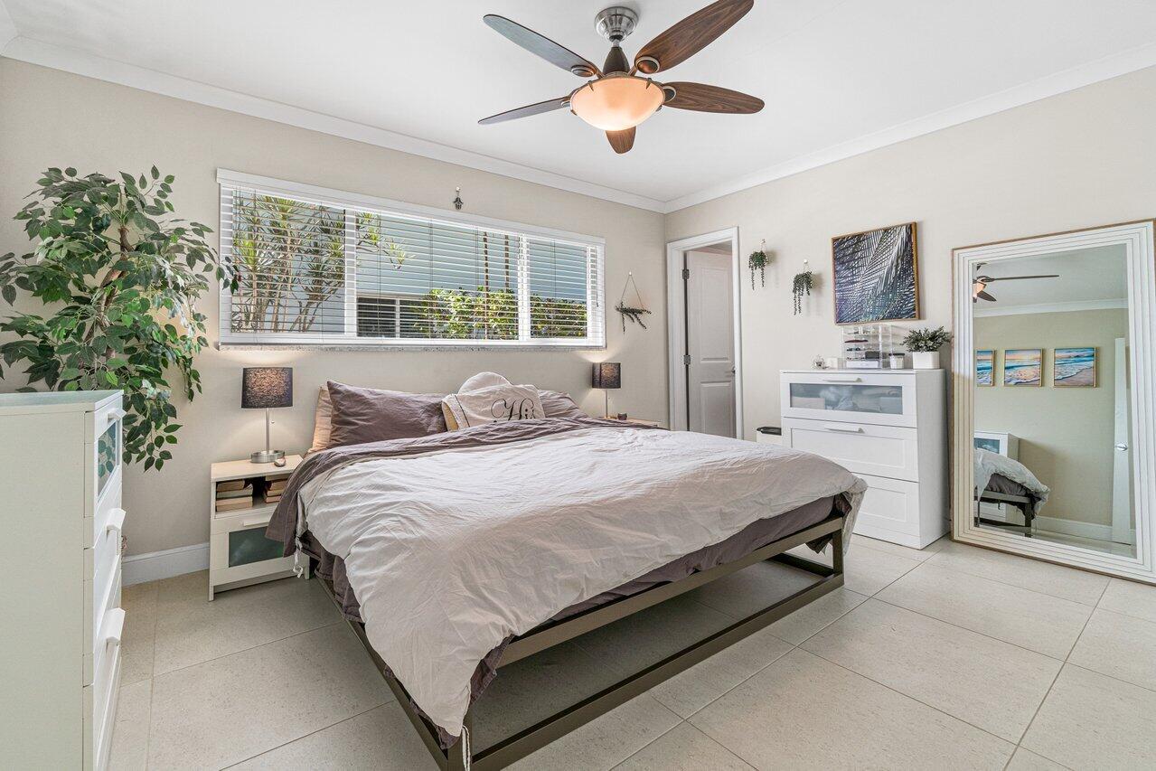 2311 Northeast 36th Street, Unit 1A Lighthouse Point, FL 33064 - Photo 12 of 29 a bedroom with a bed and a chandelier