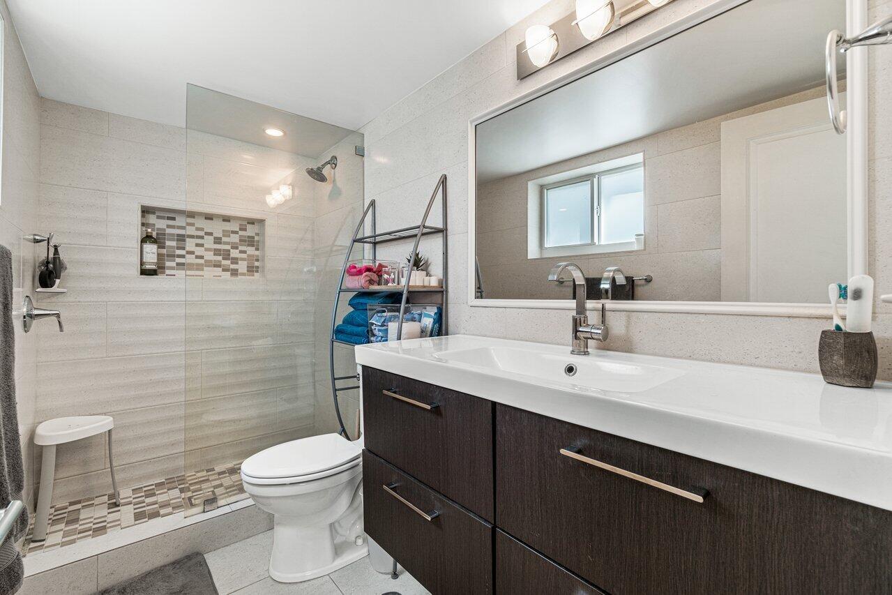 2311 Northeast 36th Street, Unit 1A Lighthouse Point, FL 33064 - Photo 14 of 29 a bathroom with a sink a toilet and shower