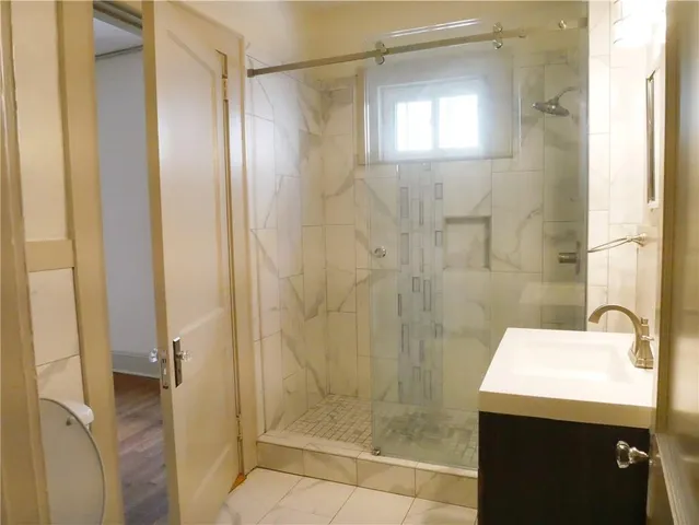 a bathroom with a shower a sink and a mirror