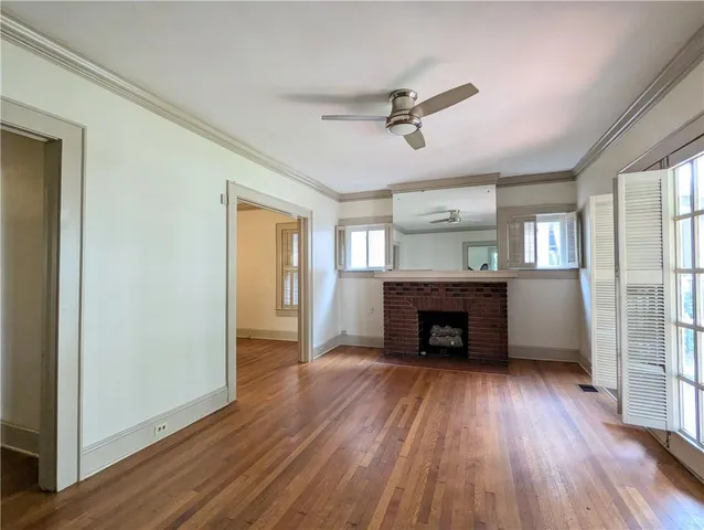 wooden floor fireplace and windows in an empty room