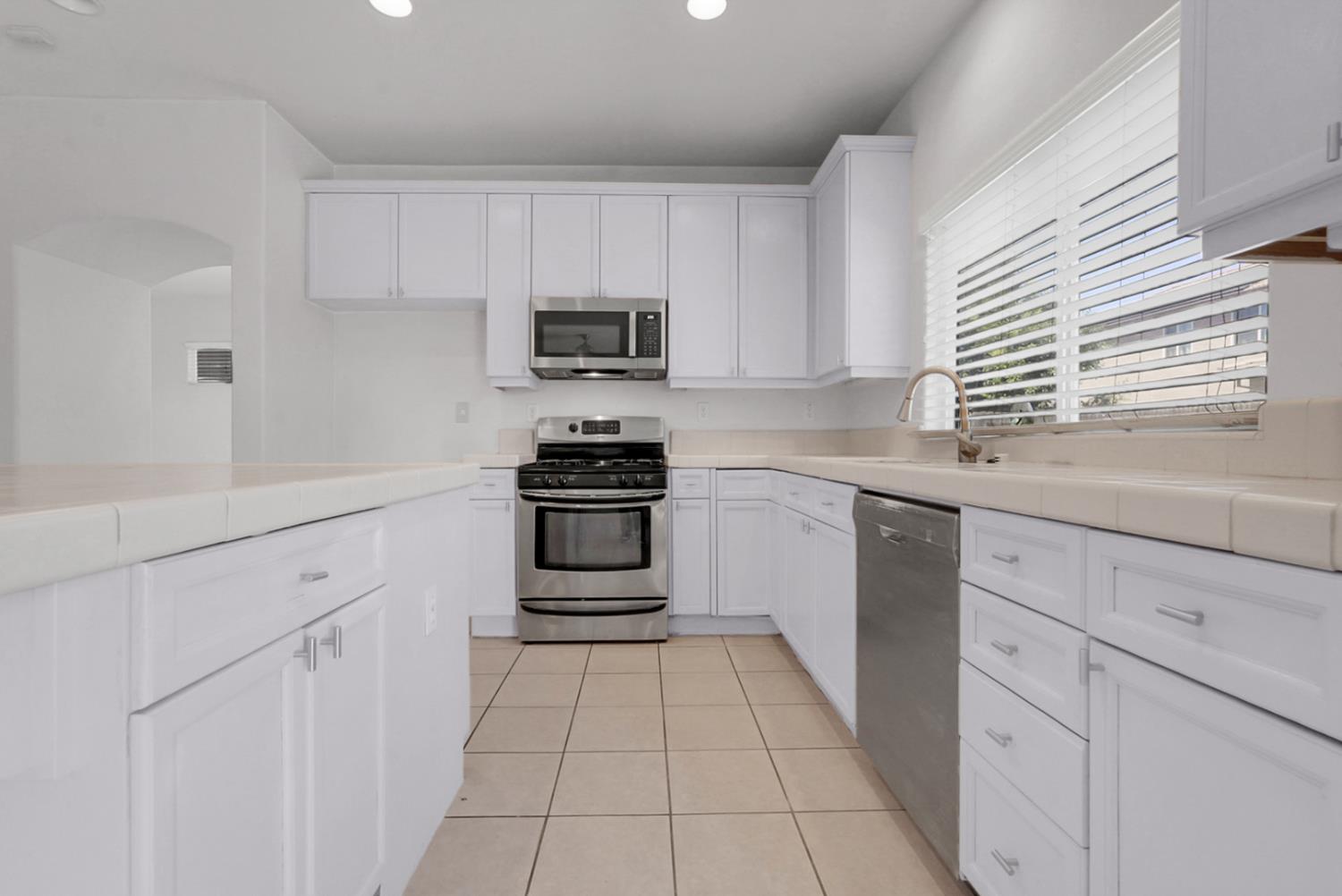 1412 Red Ribbons Lane Manteca, CA 95337 - Photo 8 of 32 a kitchen with white cabinets stainless steel appliances and sink