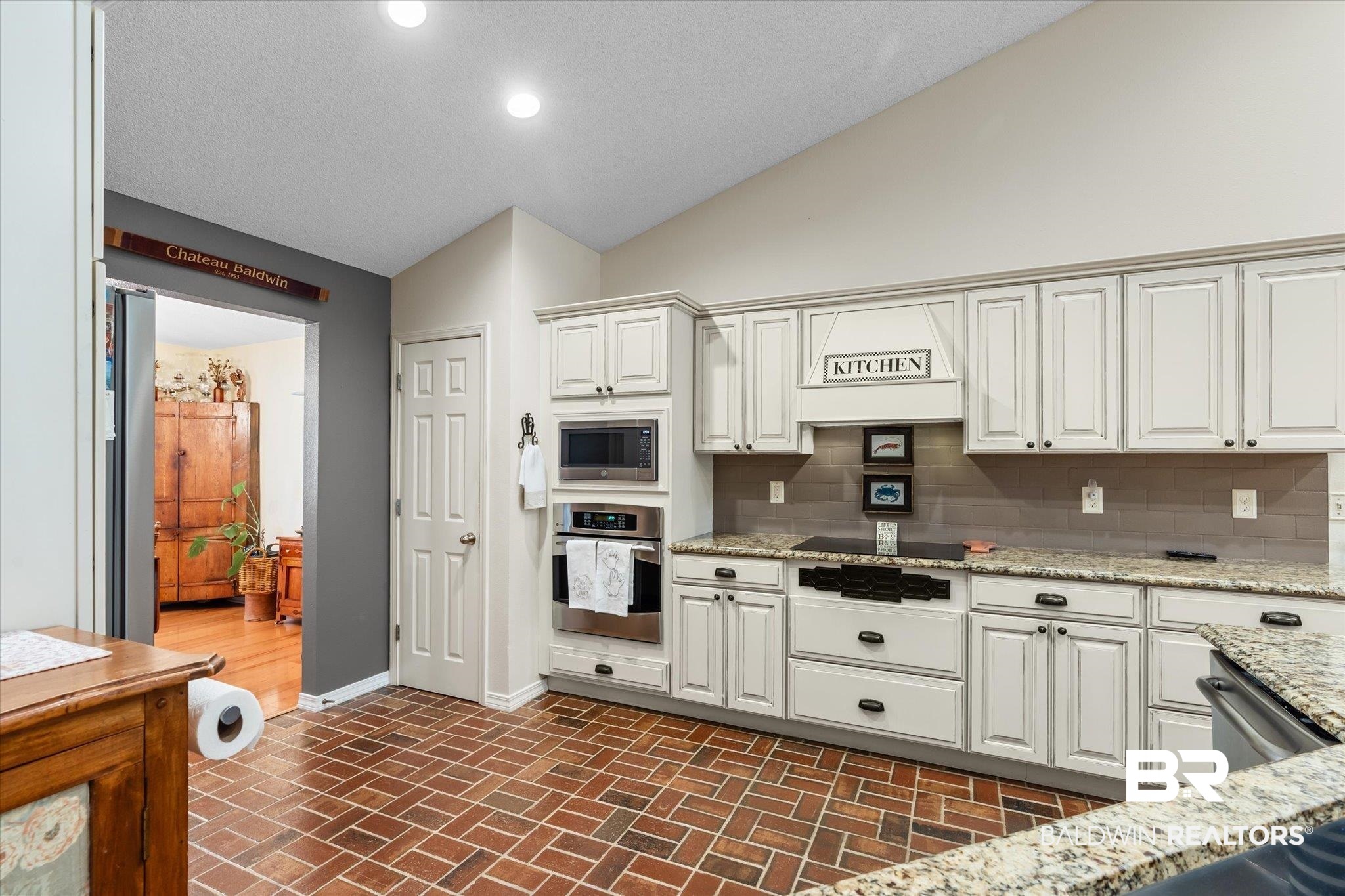 356 Collinwood Loop Foley, AL 36535 - Photo 2 of 21 Kitchen featuring light stone countertops, stainless steel appliances, backsplash, vaulted ceiling, and white cabinets