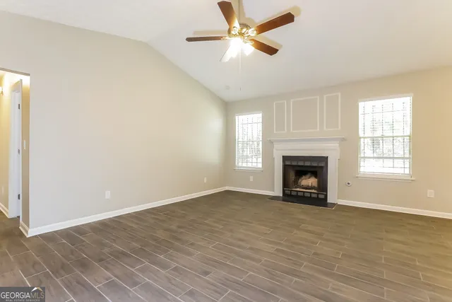 a view of empty room with fireplace and fan