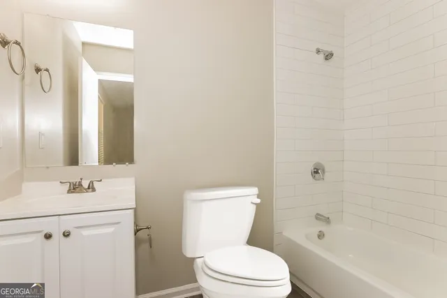 a bathroom with a bathtub shower sink mirror vanity and toilet
