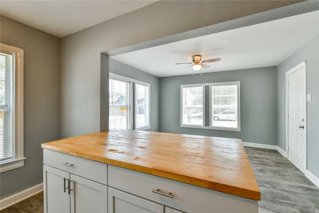 a view of an empty room with window and wooden floor