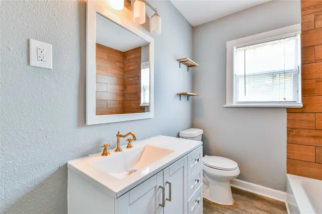 a bathroom with a sink a toilet and a window