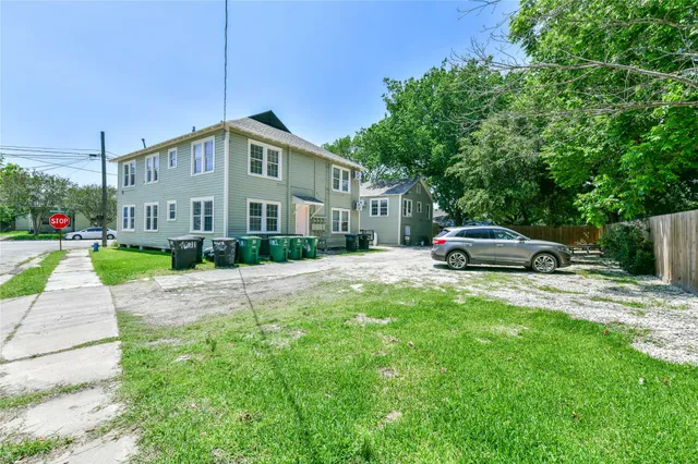 a car parked in front of white house with a yard