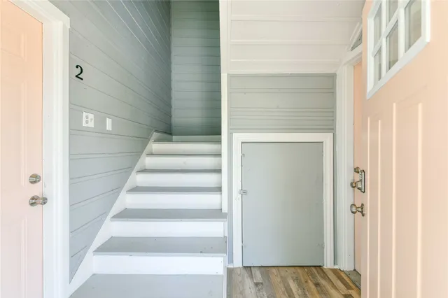 a view of staircase with white walls and white door