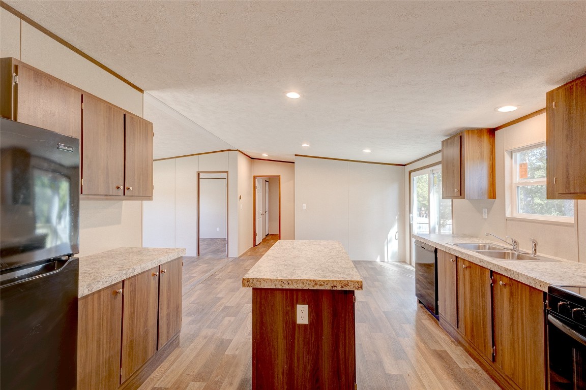 107 Los Cueva Road Elgin, TX 78621 - Photo 13 of 31 a large kitchen with kitchen island granite countertop wooden cabinets a sink and dishwasher