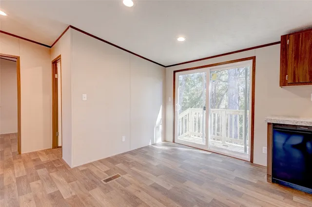 a view of empty room with wooden floor and fireplace
