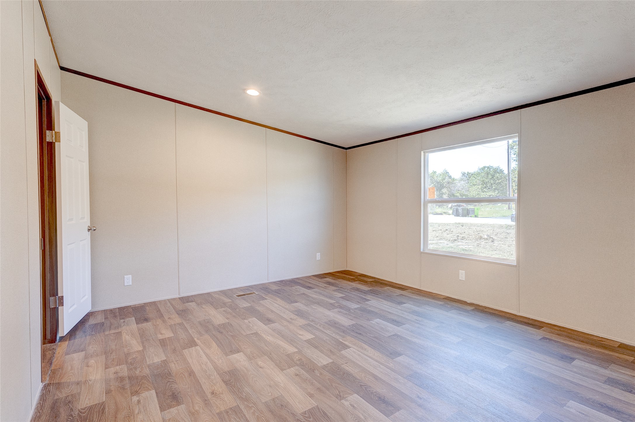 107 Los Cueva Road Elgin, TX 78621 - Photo 27 of 31 an empty room with wooden floor and windows