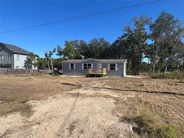 a front view of a house with a yard and trees