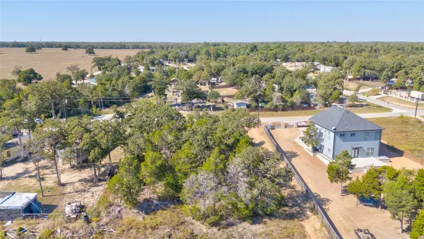 an aerial view of residential houses with outdoor space and trees