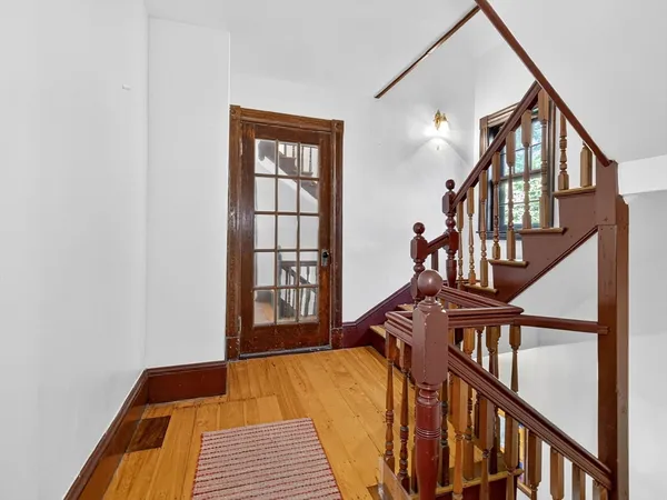 a view of staircase with wooden floor and a window