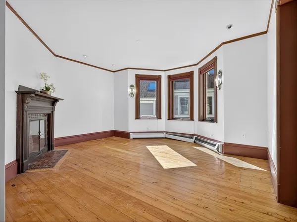a view of an empty room with glass door and wooden floor
