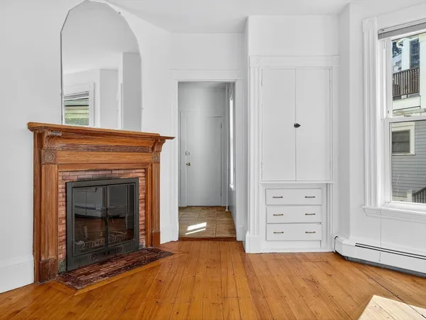 a view of an empty room with furniture and a fireplace