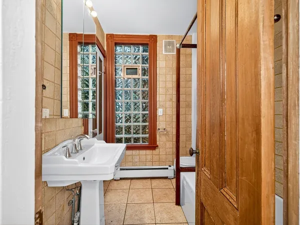 a bathroom with a sink a mirror and next to a window