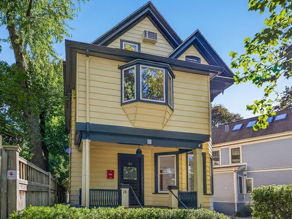 a front view of a house with a yard and potted plants