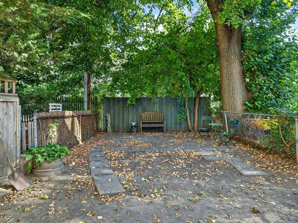 a view of a backyard with large trees and plants