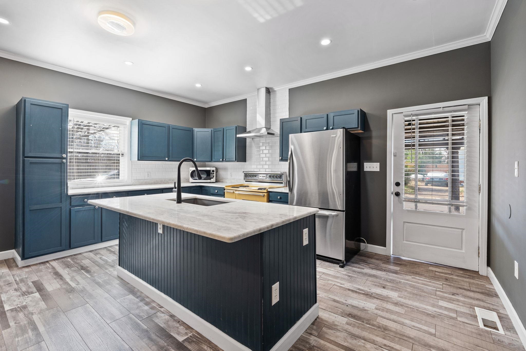 a kitchen with stainless steel appliances granite countertop a sink stove and refrigerator