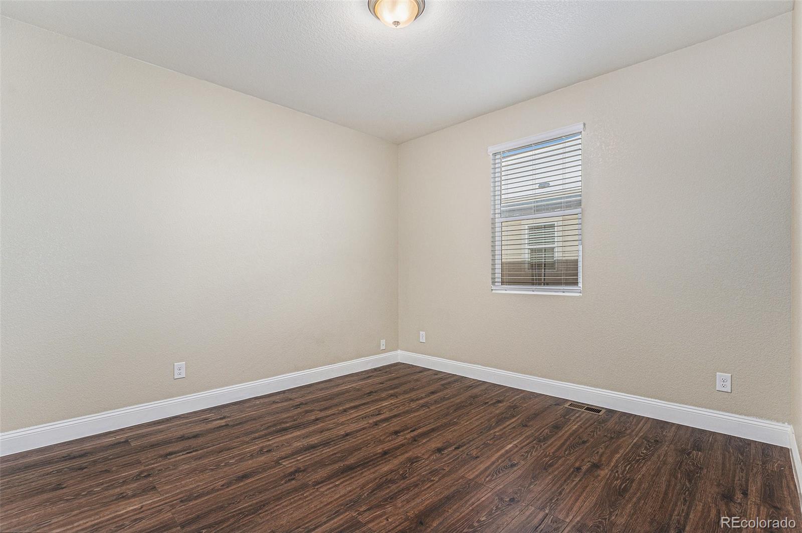 1051 Draw Street Brighton, CO 80603 - Photo 15 of 19 a view of a room with wooden floor and windows