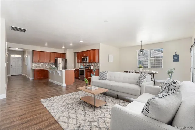 a living room with furniture and kitchen view