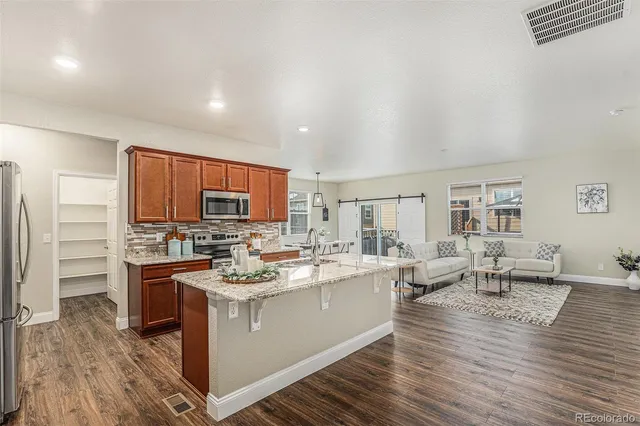 a open kitchen with a sink stove and wooden floor