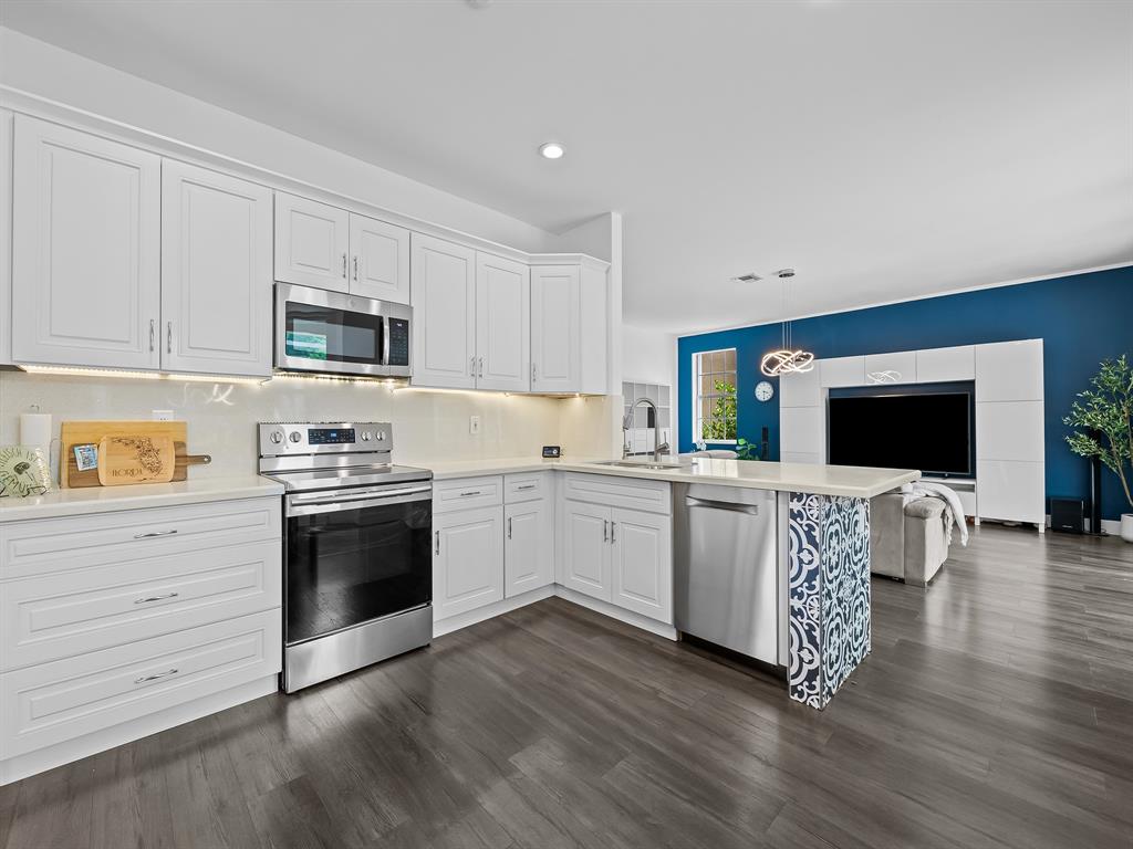 301 Cameron Drive Weston, FL 33326 - Photo 14 of 39 a kitchen with stainless steel appliances white cabinets and a stove top oven