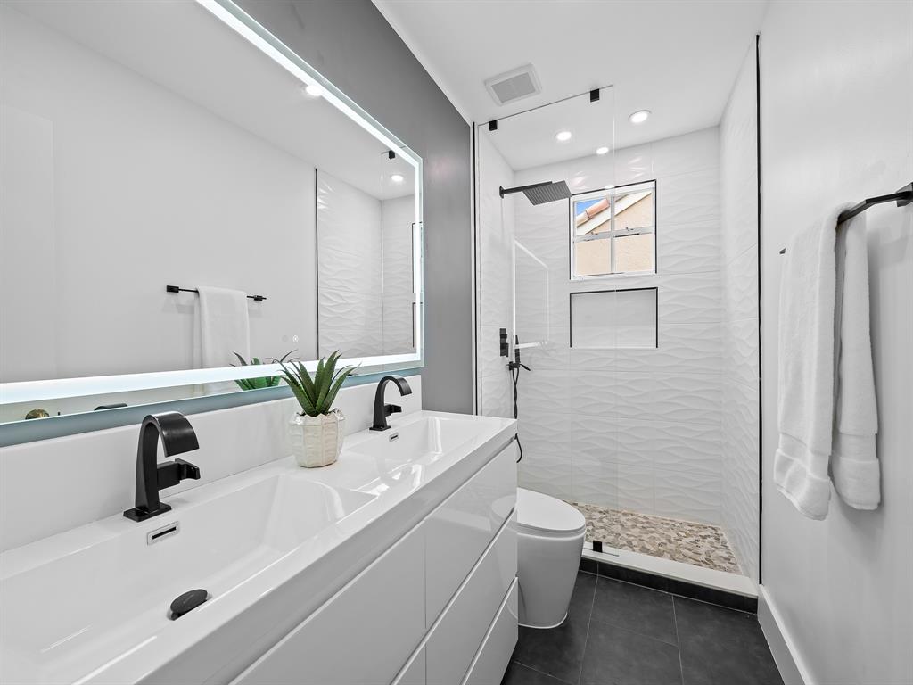 301 Cameron Drive Weston, FL 33326 - Photo 25 of 39 a bathroom with a double vanity sink toilet and shower