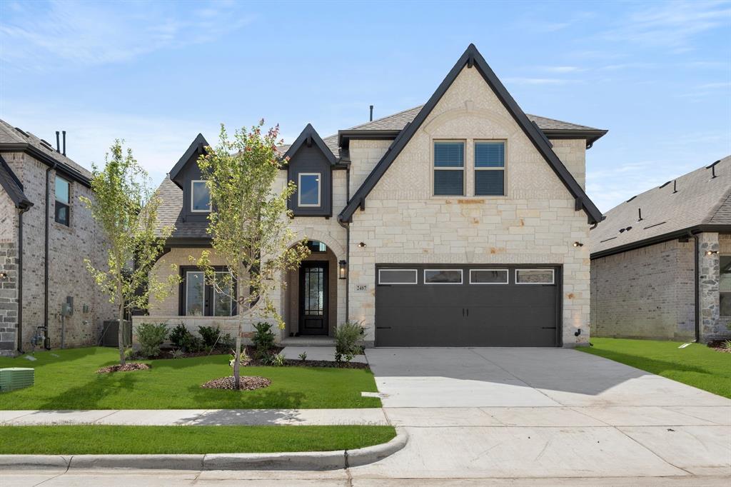 a front view of a house with a garden and garage