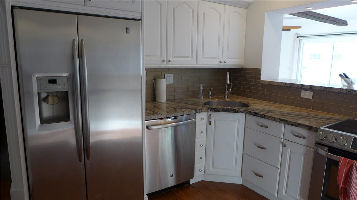 809 North Victoria Park Road Fort Lauderdale, FL 33304 - Photo 3 of 25 a kitchen with stainless steel appliances granite countertop a refrigerator and a sink