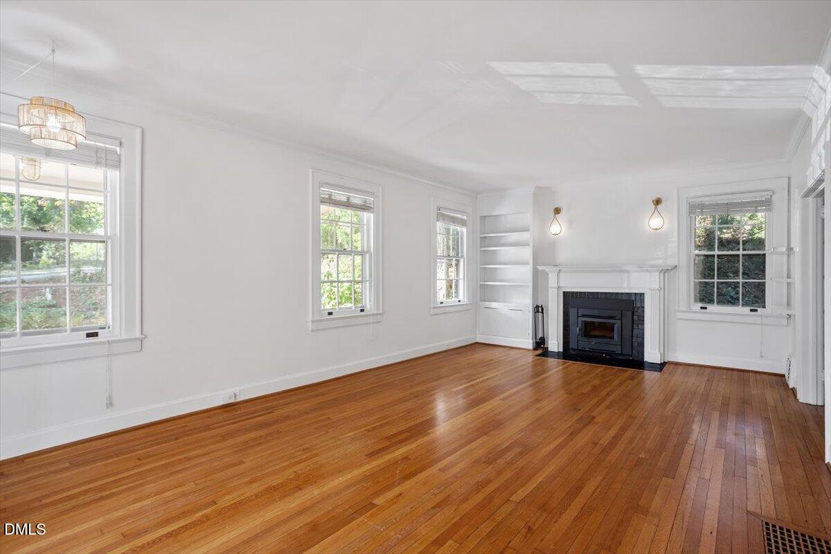 2201 Byrd Street Raleigh, NC 27608 - Photo 14 of 37 an empty room with windows fireplace and wooden floor