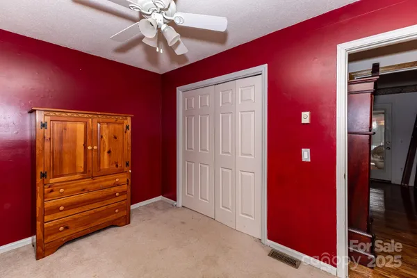 a view of a livingroom with wooden floor and a ceiling fan