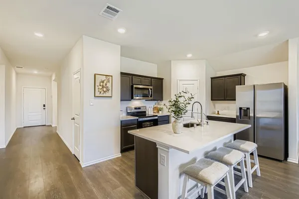 a kitchen with stainless steel appliances a refrigerator and a stove top oven