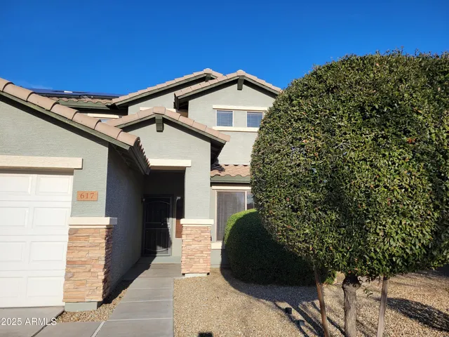 a view of a house with a large window and potted plants